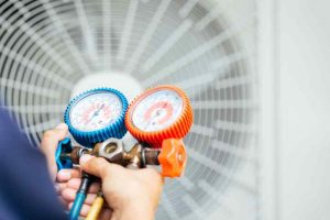 Air conditioning technician with freon gauges preparing to install a new air conditioner