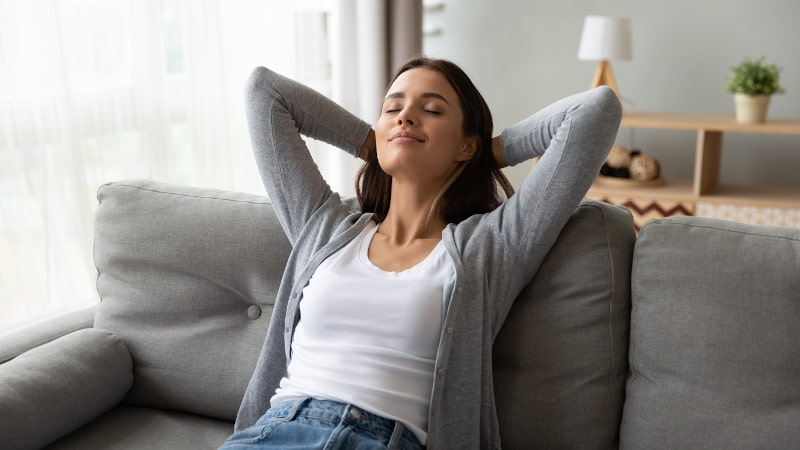 Woman enjoying home air comfort from a whole-house humidifier system