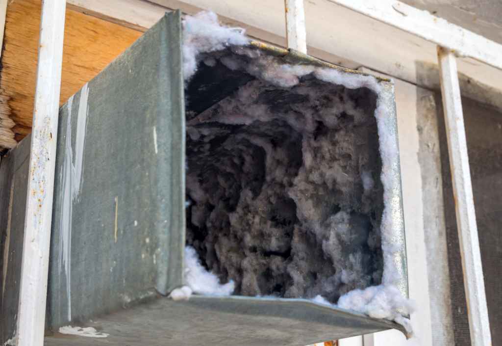 Dirty air duct with dust and debris buildup, highlighting the need for professional air duct cleaning before the fall season.