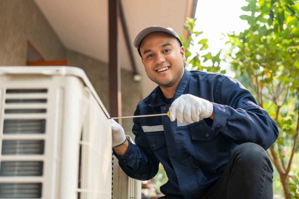 AC Repair technician servicing an outdoor air conditioning unit.